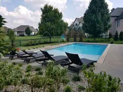 Finished backyard pool with fencing and mature landscaping